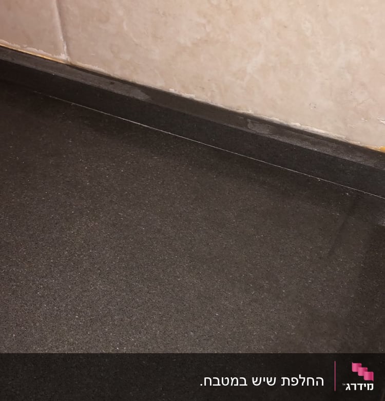 משטח שיש כהה ליד קיר בהיר